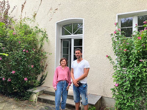 Eine Frau und ein Mann vor einem Haus
