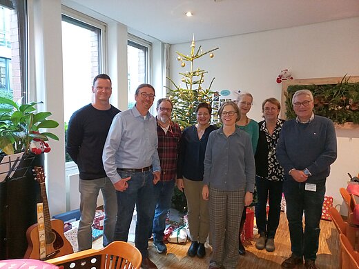 Gruppenbild vor einem geschmückten Weihnachtsbaum