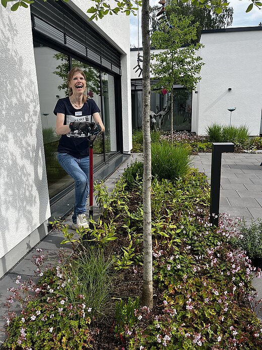 Eine Frau bei der Gartenarbeit mit Spaten.